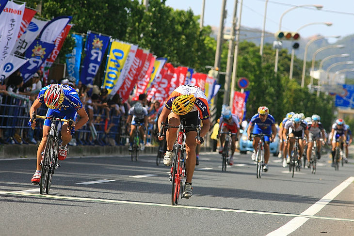 中鶴友樹(TEAM KIDS)と阿部紘太(法政大学サイクリング同好会)が自転車を投げあう