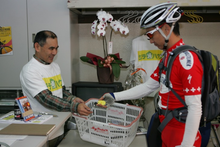 自転車にかけられた鍵と着替えを入れるためのカゴが佐野さんに渡される