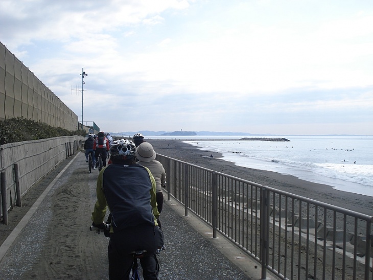 サーファー達が浮かぶ海岸沿いを走る