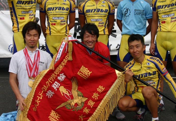 2007年の全日本実業団対抗ロードでチーム優勝を飾り同時にルビーレッドジャージを獲得した中村。栗村監督と柿沼キャプテンに挟まれて会心の笑顔を魅せる。