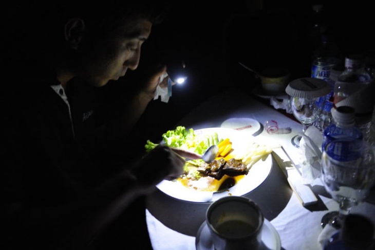 大会前夜の夕食会で小さな灯りで食事をする田中監督