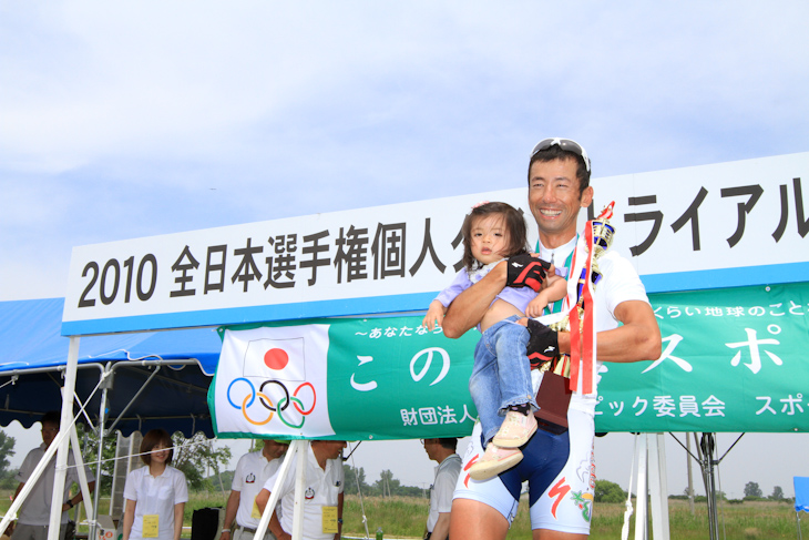 表彰台で愛娘を抱き上げる福島晋一(クムサン・ジンセン・アジア)