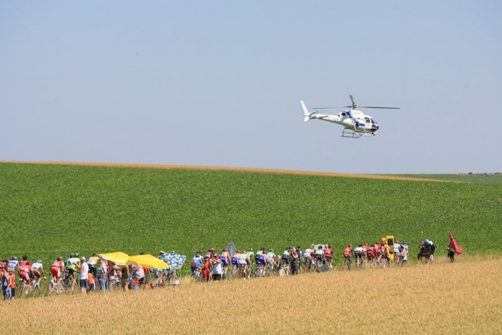 ヘリコプターが低空飛行で選手を撮影中