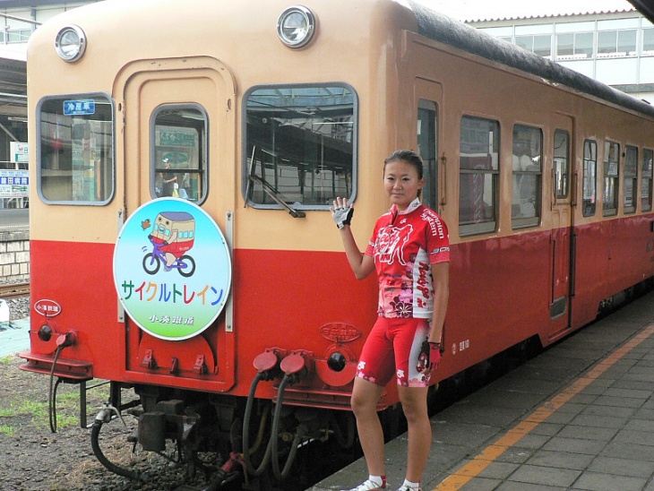 小湊鉄道サイクルトレインの開催時だけ取り付けられる「特製ヘッドマーク」とRGJ武田和佳選手。彼女はこのヘッドマークデザインも担当した