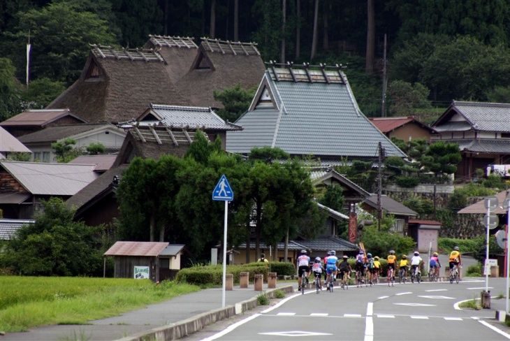 かやぶき屋根の家屋が残るのどかな佇まいの美山町を、自転車が走る町に