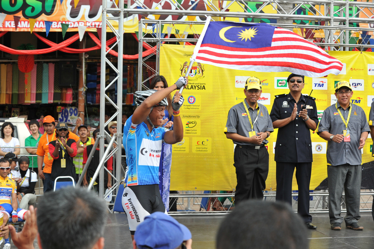 レースリーダーのプレゼンテーションでマナンが国旗を振る