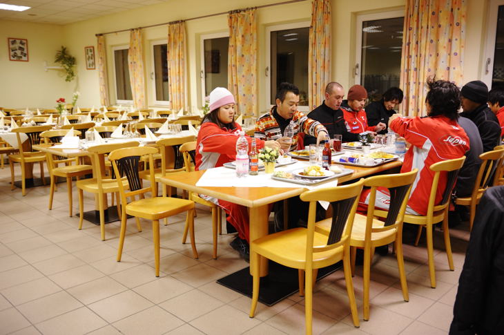 学生食堂のような施設で夕食を取る日本チーム