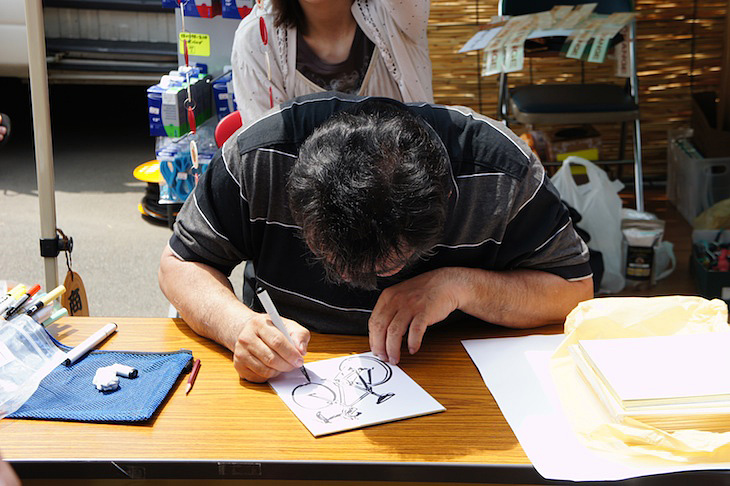 人気コミック「アオバ自転車店」の作者・宮尾岳先生のサイン会も実施。宮尾先生は1枚1枚丁寧に書かれていた