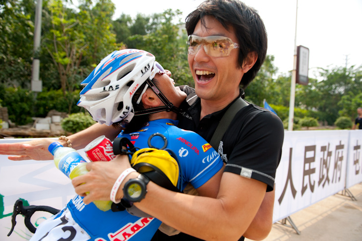 ツアー・オブ・ハイナン2011第2ステージで優勝した中島康晴（愛三工業）が別府匠監督と抱きあって喜ぶ