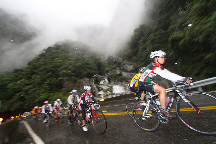 雨の降りしきる中タロコ渓谷を走る選手たち