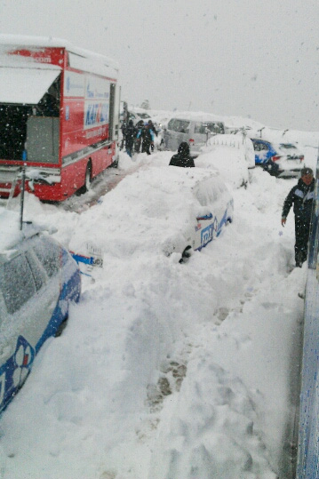 雪に埋もれたトラックやチームカー