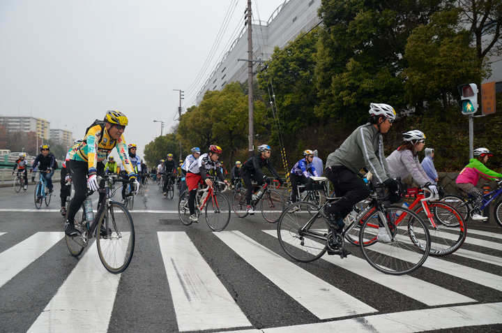 大勢のサイクリストが港湾地区を走っていく