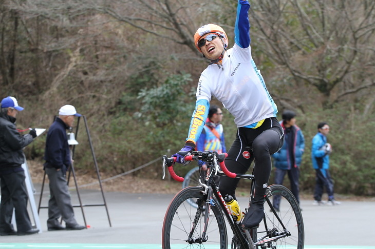 左腕を高々と挙げてゴールする斉藤英代選手(コミヤマレーシング)