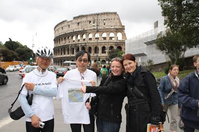 ローマのコロッセオ前にゴールし、ドイツ人観光客に走行ルートの地図を説明する参加者