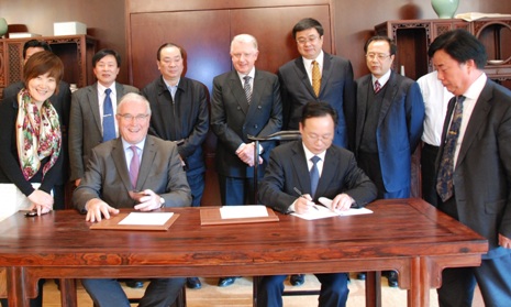 契約書にサインするパット・マックエイドUCI会長と杭州市の関係者
