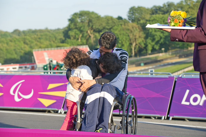 初めてのパラリンピックの表彰台で、子供を抱きしめるコービー・ライアン。ロード個人TT（男子H１）表彰