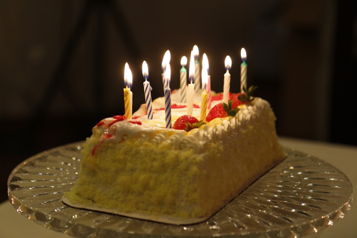 結婚パーティに用意されたケーキにキャンドルライトが灯る
