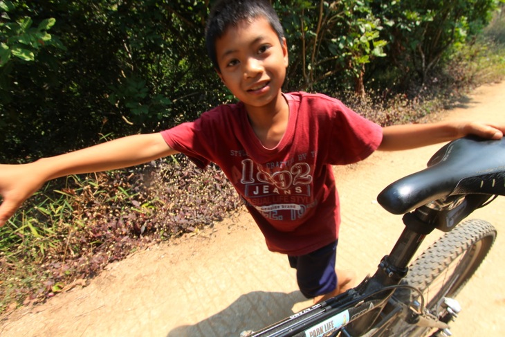 駆け寄ってサドルを押してくれる山岳民族の子供。コップンカー（ありがとう）