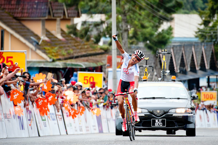 第3ステージ　片手を突き上げてゴールするワン・メイイン（中国、ハンシャンサイクリング）