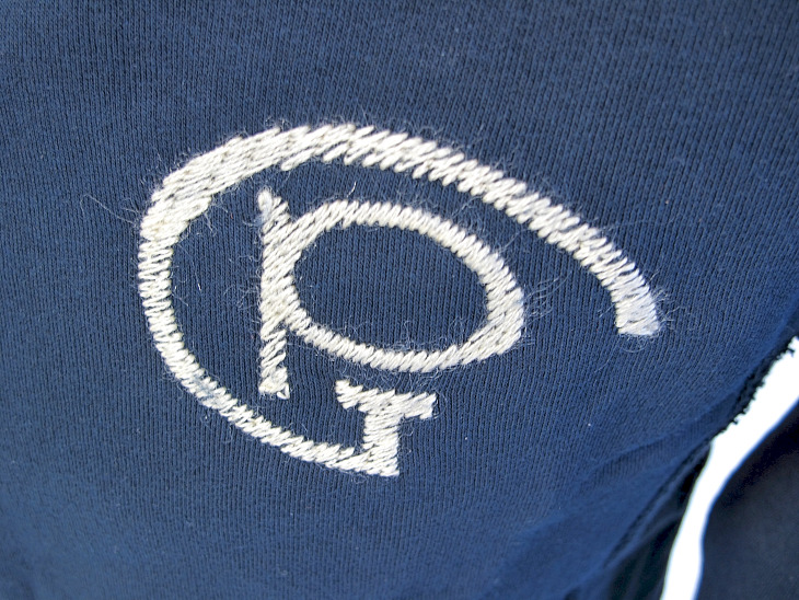 胸に刺繍された旧デザインのロゴ（ネイビーのみ）