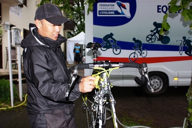 第2ステージ終了後　雨で汚れた自転車を洗車する山脇メカニック（チクロイプシロン）。今回はレース中のホイール破損が続き、予備機材を多くは持ち込めないチームにとって厳しい状況であったが、限られた道具の中で深夜まで完璧に対応してくれた