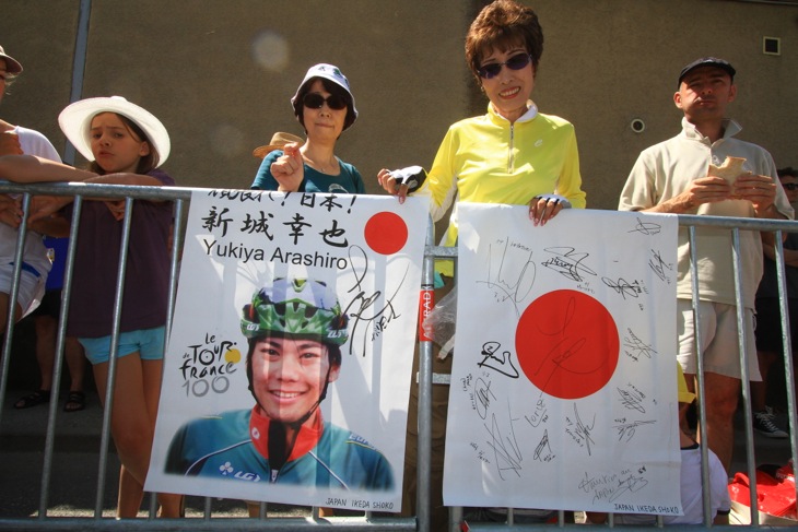 スタート地点に駆けつけた日本人ファンが新城幸也の応援バナーを掲げる