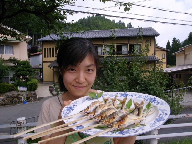 沿道で鮎の塩焼きサービスの売店をだしていた地元の老舗旅館「枕川楼」の娘さん。「このイベントに関わるのが本当に楽しい」そうだ