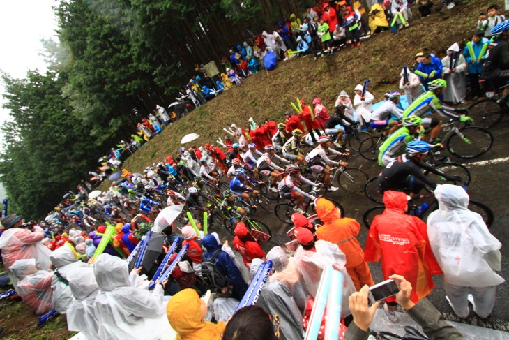 雨の中大勢のファンの待つ古賀志林道を駆け抜ける選手たち