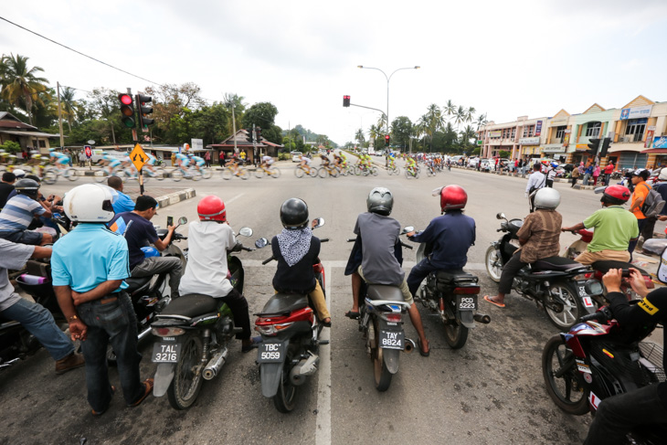 交通規制によりストップしたバイクのドライバーたちがレースを見守る