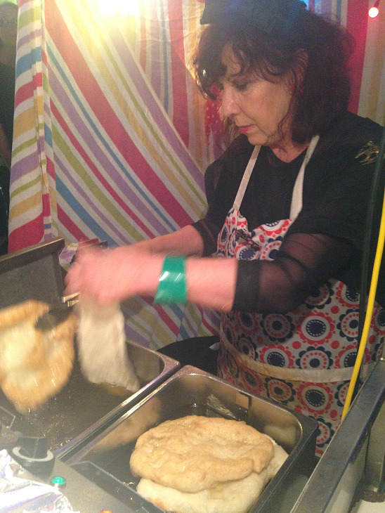屋台でおばちゃんが作っているのはLANGOSという揚げパンの様な食べ物。生のにんにくを擦りつけ、パプリカのパウダーをふりかけて食べる