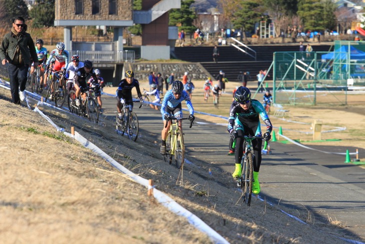 土手のキャンバーを行く選手たち。藤田拓海(SNELCYCLOCROSSTEAM)がトップを猛追する