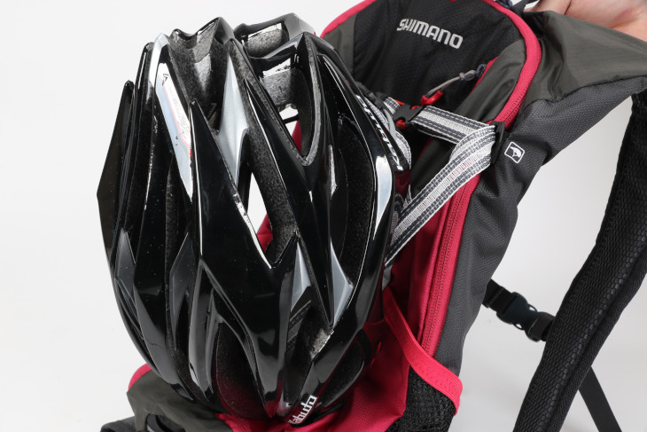 バッグ正面のフックはヘルメットホルダーの役割があり、意外とかさばりやすいヘルメットをスマートに持ち運ぶことが可能だ