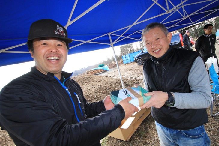 中沢清さんが永井隆正さん（サイクランドコーフー）に冊子を手渡しする