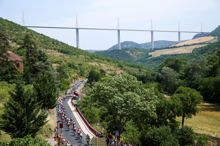 「世界一高い橋」として知られるミヨー橋（主塔の高さ343m）の下を通過するプロトン