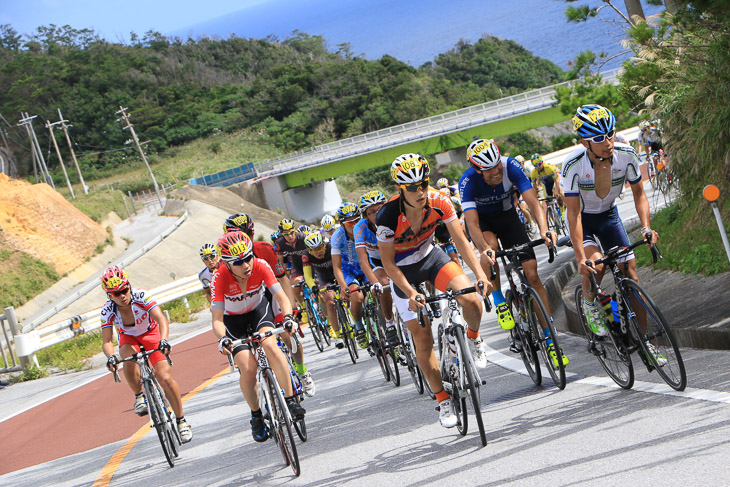 東海岸のアップダウンを行く市民140kmのメイン集団　中央に優勝した横塚 浩平（オーベスト）