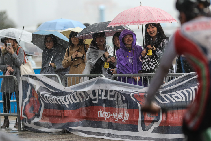 吹きすさぶ風と雨のなか観戦する熱心な女性ファンたち。悪天候は思いのほか長引いた