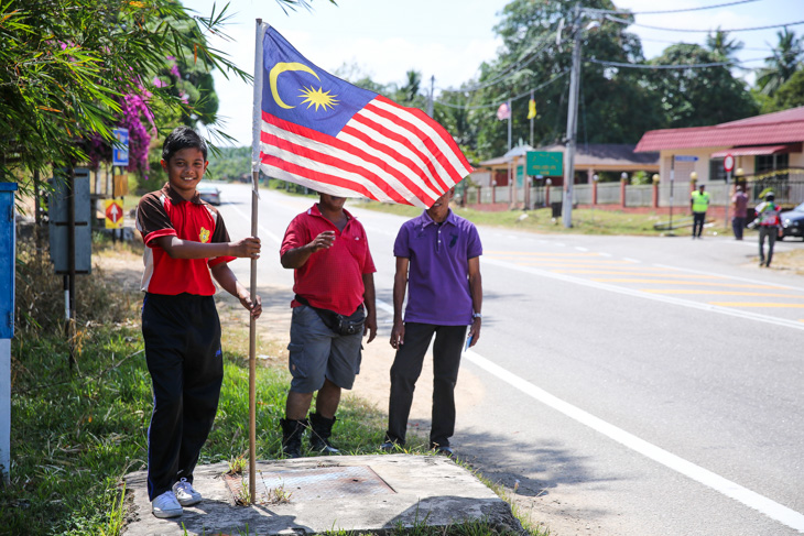 マレーシア国旗を手にレースを待つ