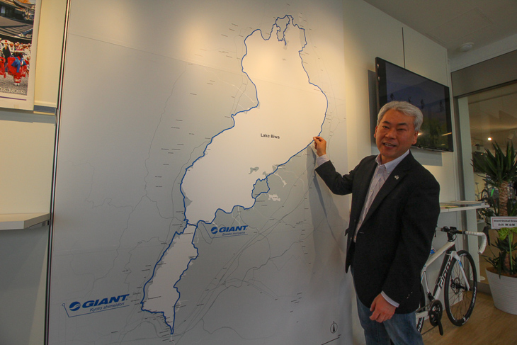 店舗入口の琵琶湖サイクリングマップと中村晃ジャイアント・ジャパン社長