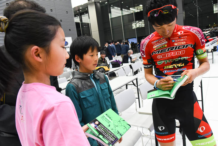 TOJキッズの2人にサインする増田成幸（宇都宮ブリッツェン）