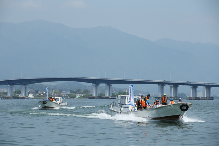 琵琶湖大橋を背後に湖面を快走する漁船タクシー