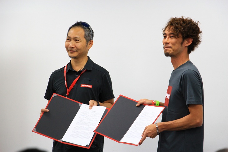 会の冒頭、スラム・アジアセールスディレクターのビリー・ユー氏とインターマックス・木下氏が契約書を交わした