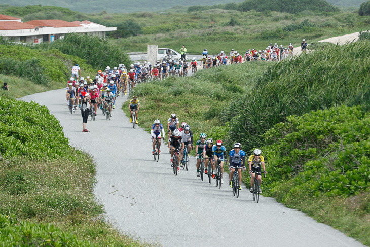 東平安名崎灯台へと続く道を走る114kmの選手たち