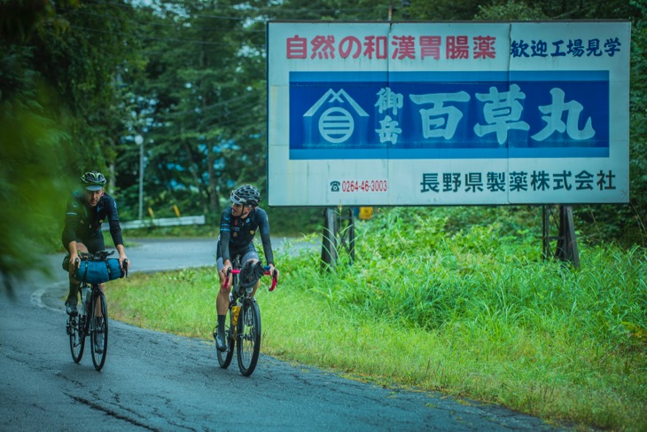 代表的な木曽名物百草丸の看板を通り過ぎるオーガナイザー。山深く植生の豊かなこの土地で、天然由来の植物成分から抽出される常備胃腸薬として江戸期から全国に知られてきた
