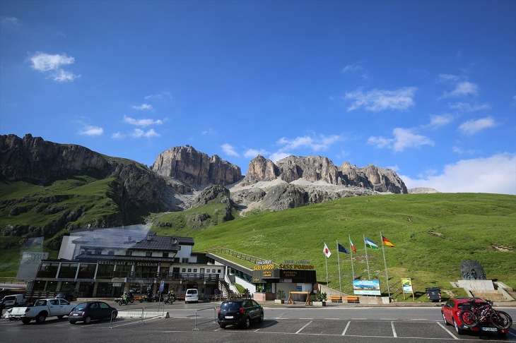 360度の山岳絶景が楽しめるドロミテ街道最高地点のポルドイ峠。ロープウェイ乗り場から、そびえ立つサッソ・ポルドイ(2,950m)の岩肌を見上げる