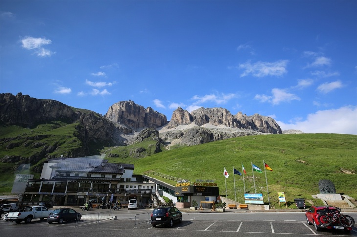 360度の山岳絶景が楽しめるドロミテ街道最高地点のポルドイ峠。ロープウェイ乗り場から、そびえ立つサッソ・ポルドイ（2,950m）の岩肌を見上げる