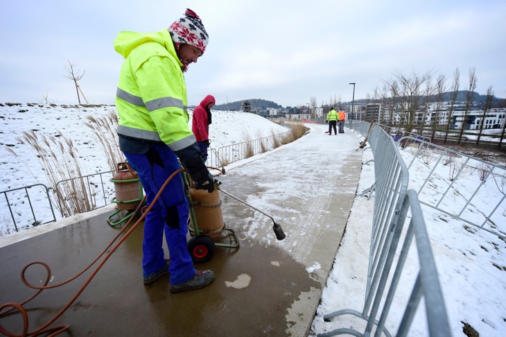 バーナーで舗装路の氷を取り除いていく