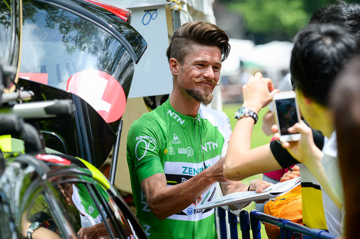 リーダージャージのオスカル・プジョル(チーム右京)はにこやかにファンサービス