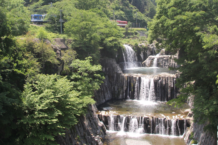 コンクリートで整備された田原の滝。ちょうど富士急行線の列車が通り過ぎる