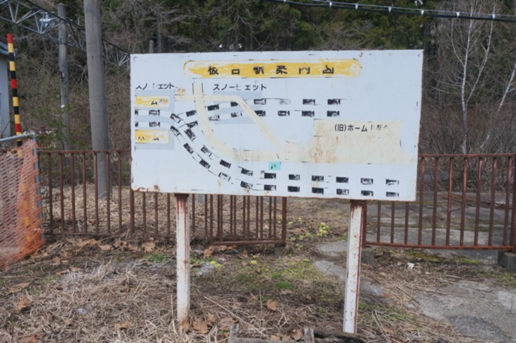 上り勾配の途中に駅を設けるため、平地の引き込み線を設けたスイッチバック駅の図、看板後ろが旧ホーム