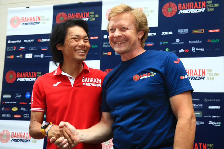 笑顔で握手する新城幸也(バーレーン・メリダ)とフィリップ・モデュイ監督